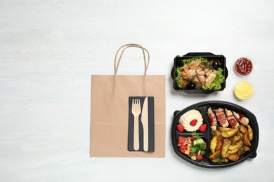 Photo of Flat lay composition with lunchboxes on white table. Healthy food delivery