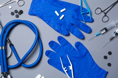 Flat lay composition with medical gloves on color background