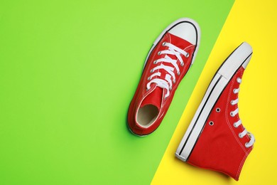 Photo of Pair of new stylish red sneakers on colorful background, flat lay. Space for text