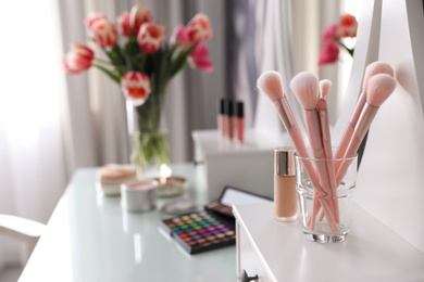 Set of cosmetic brushes in glass indoors. Interior element