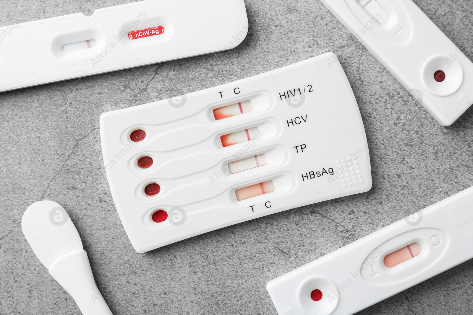 Photo of Different disposable express tests on grey table, flat lay