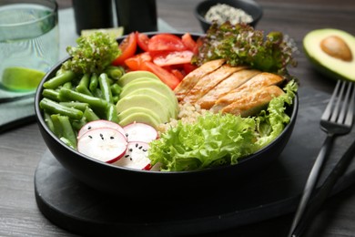 Photo of Healthy meal. Tasty products in bowl on black wooden table