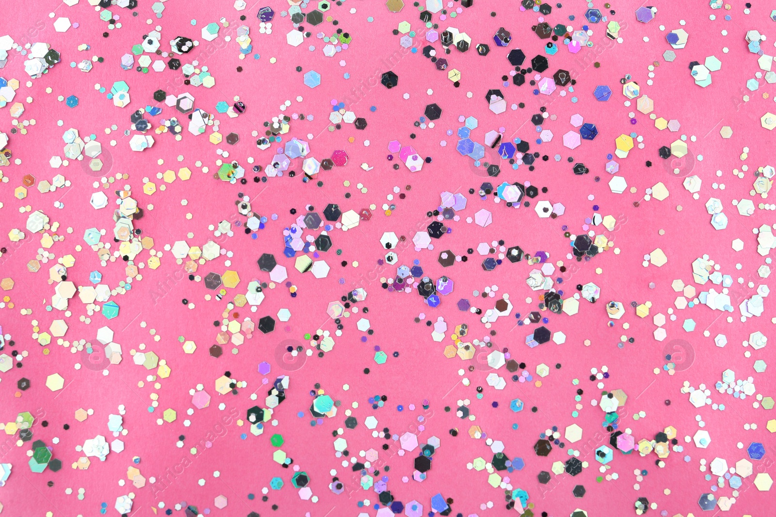 Photo of Shiny glitter on pink background, top view