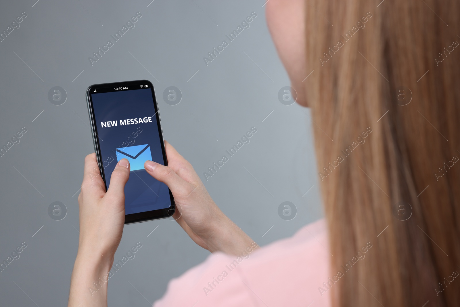 Image of Got new message. Woman using smartphone on grey background, closeup