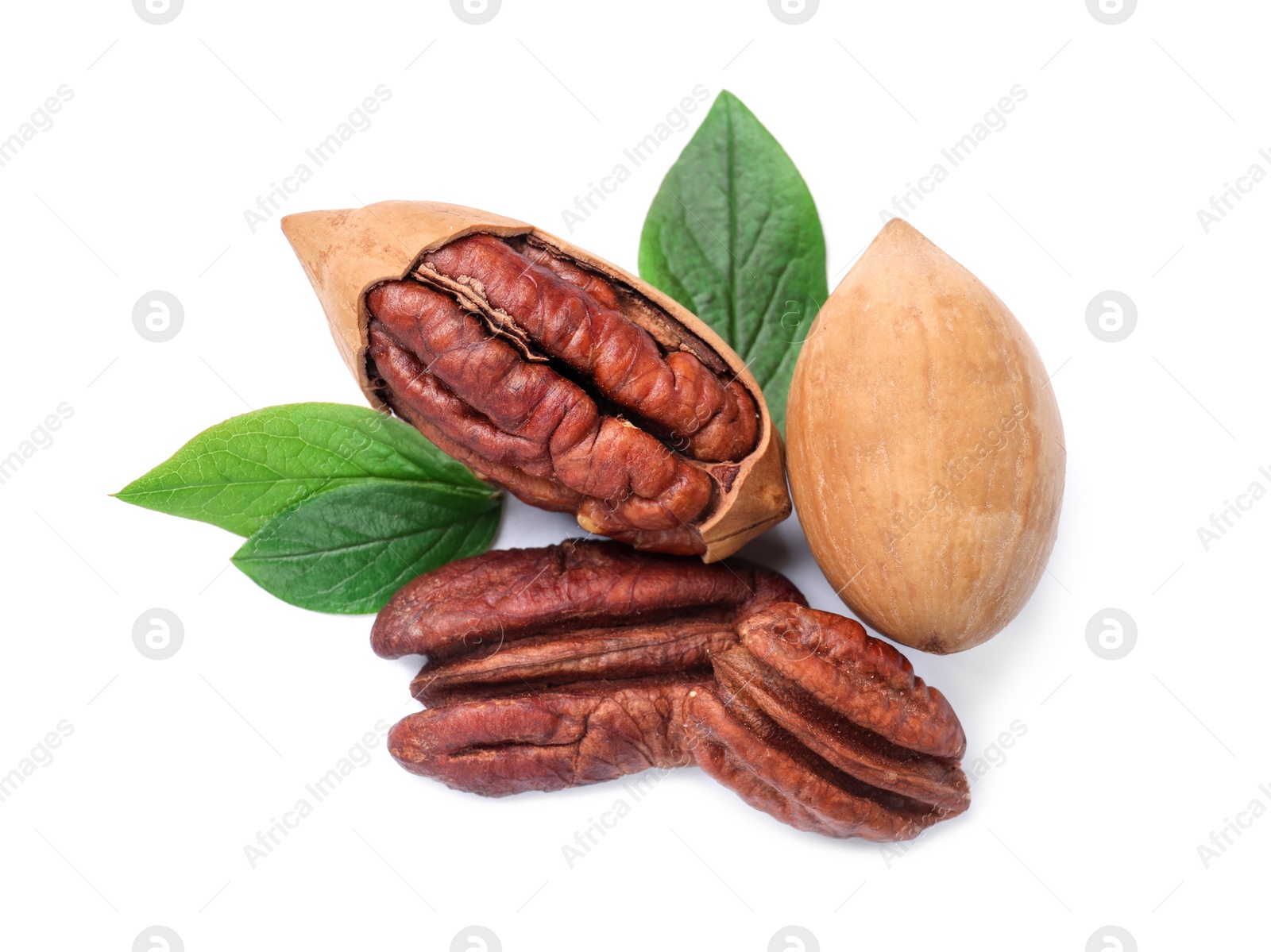 Photo of Many tasty pecan nuts with green leaves isolated on white, top view