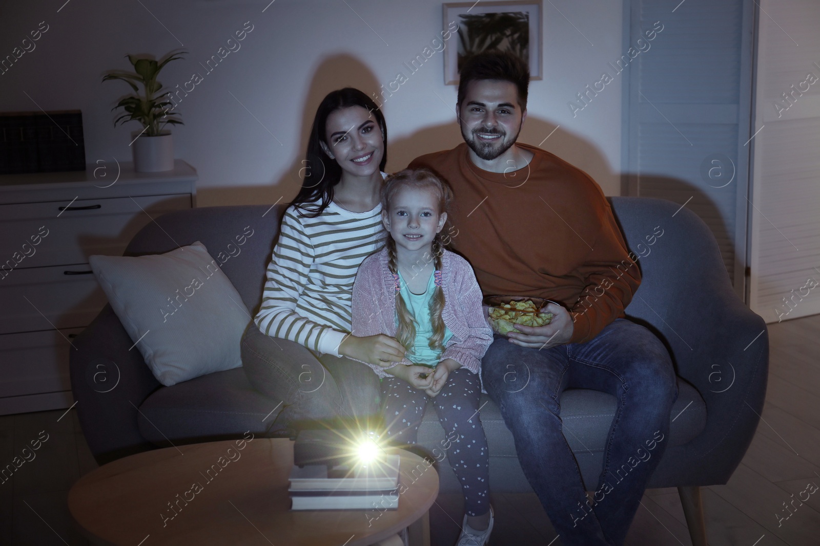 Photo of Family watching movie using video projector at home