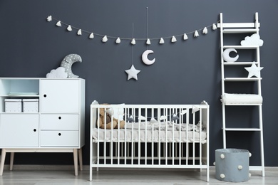 Stylish baby room interior with comfortable crib