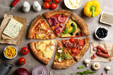 Photo of Flat lay composition with slicesdifferent delicious pizzas on grey marble table