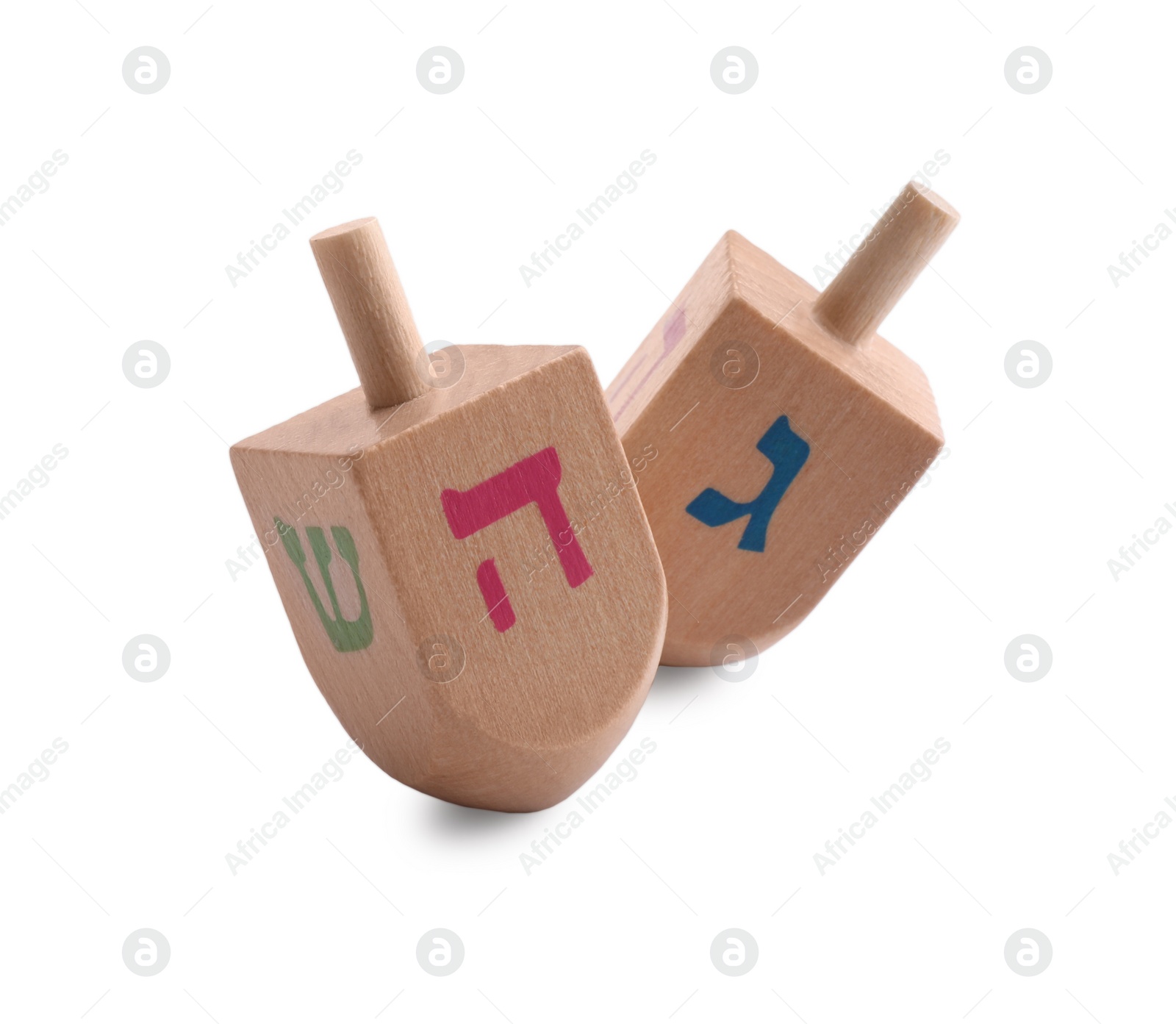 Photo of Wooden dreidels isolated on white. Traditional Hanukkah game