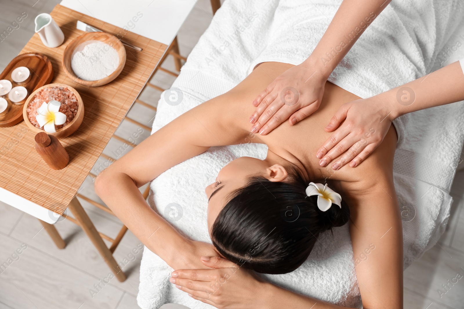 Photo of Beautiful woman receiving back massage in beauty salon, above view