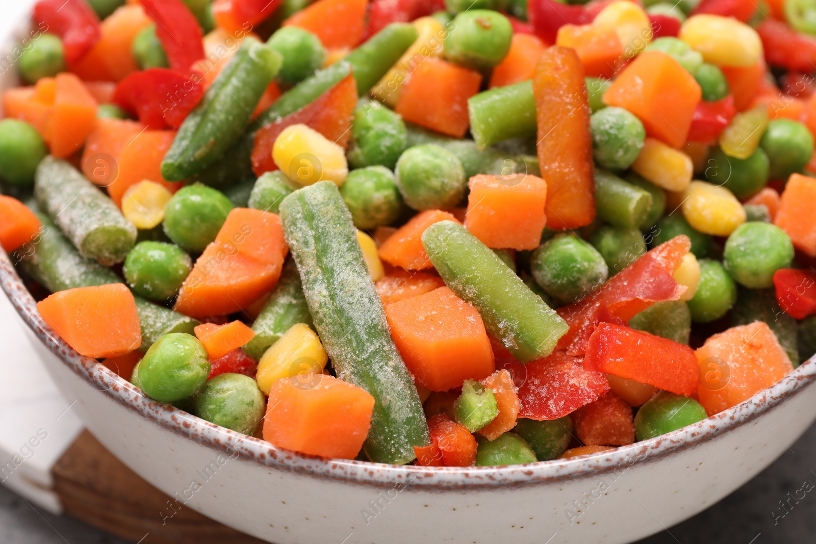 Photo of Mix of different frozen vegetables in bowl on table, closeup