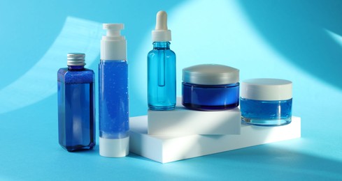 Set of luxury cosmetic products on light blue background