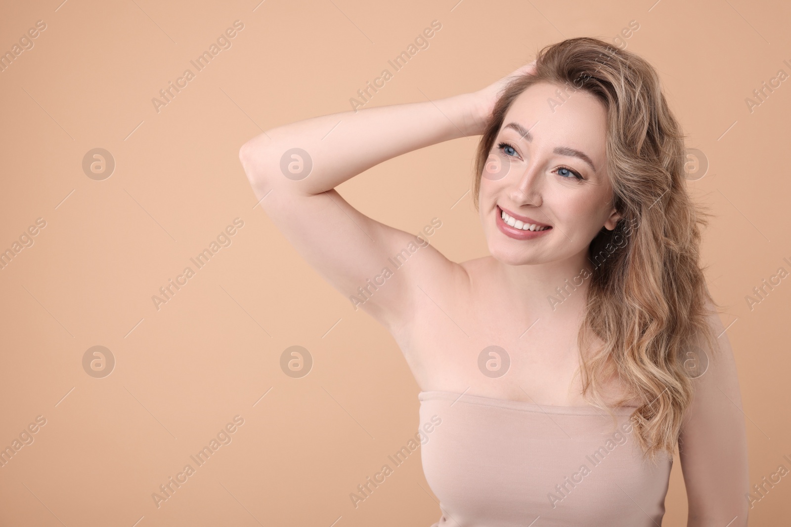 Photo of Portrait of smiling woman on beige background. Space for text