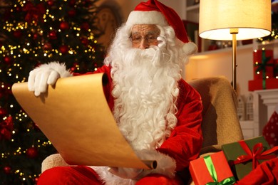 Photo of Santa Claus reading letter in room with Christmas tree