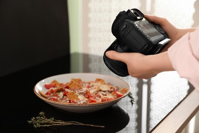 Food photography. Woman taking photo of salad with prosciutto in studio, closeup