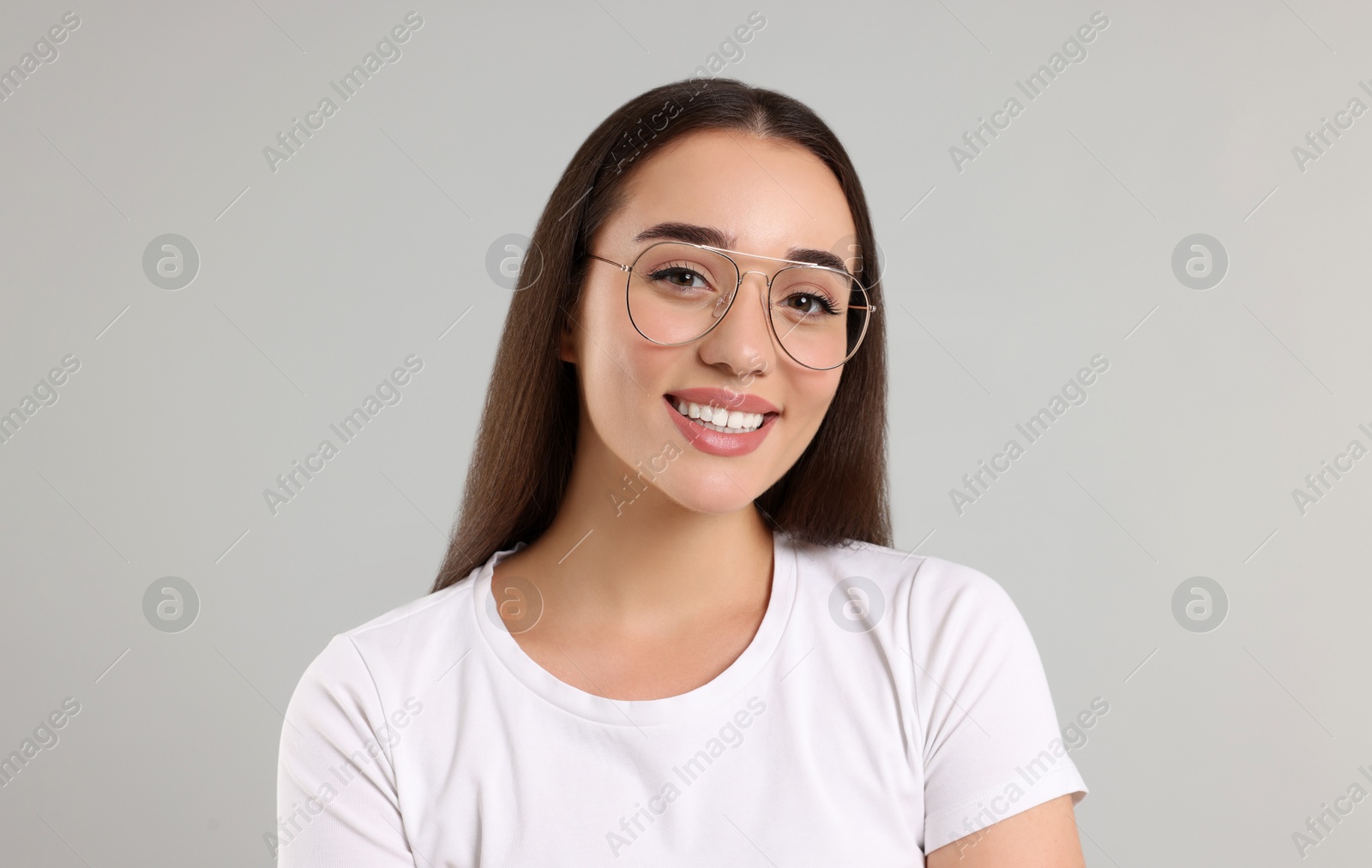 Photo of Beautiful woman wearing glasses on light gray background