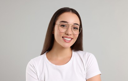 Beautiful woman wearing glasses on light gray background