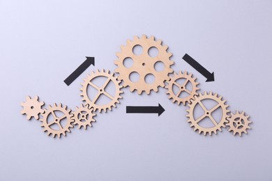 Business process organization and optimization. Scheme with wooden figures and arrows on lilac background, top view