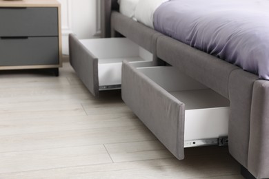 Storage drawers for bedding under modern bed in room