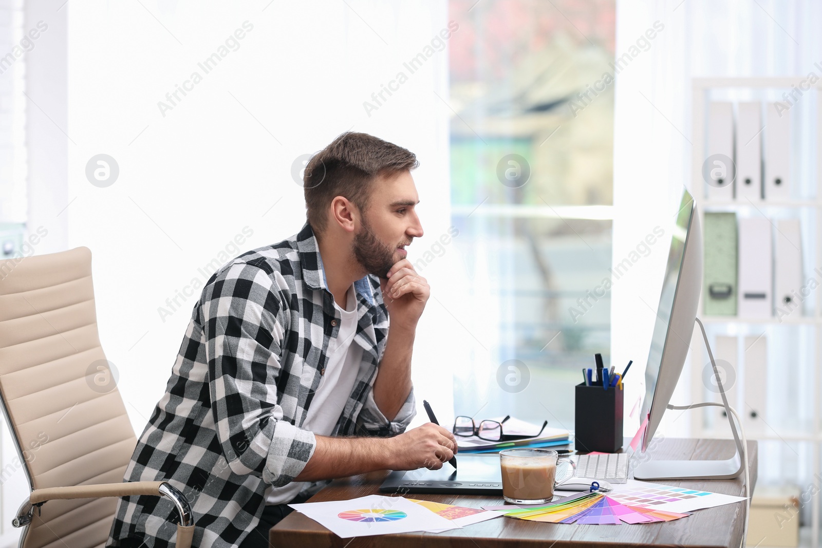 Photo of Male designer working at desk in office