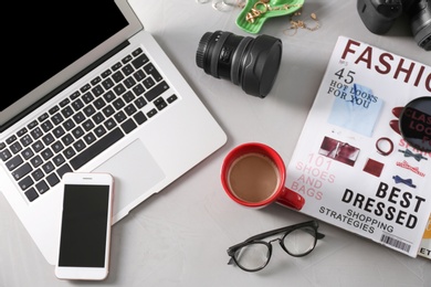 Blogger work space with cup of coffee and laptop on table, flat lay