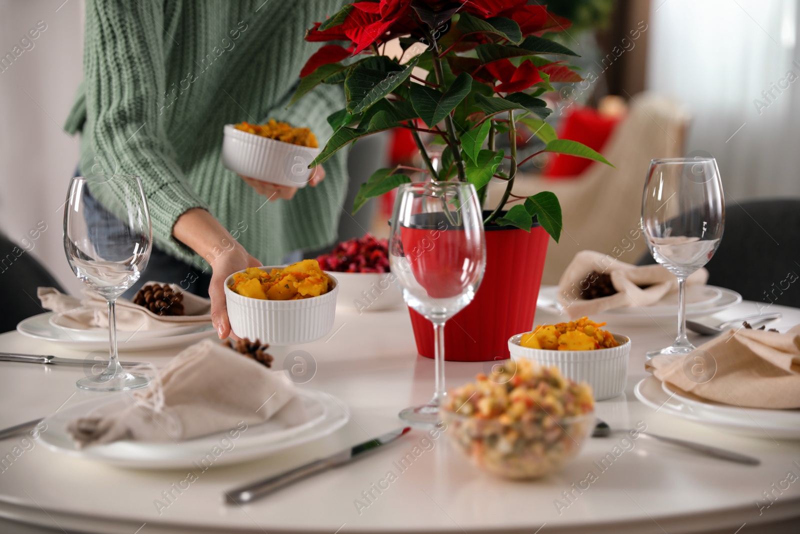 Photo of Woman setting table for Christmas dinner at home, closeup