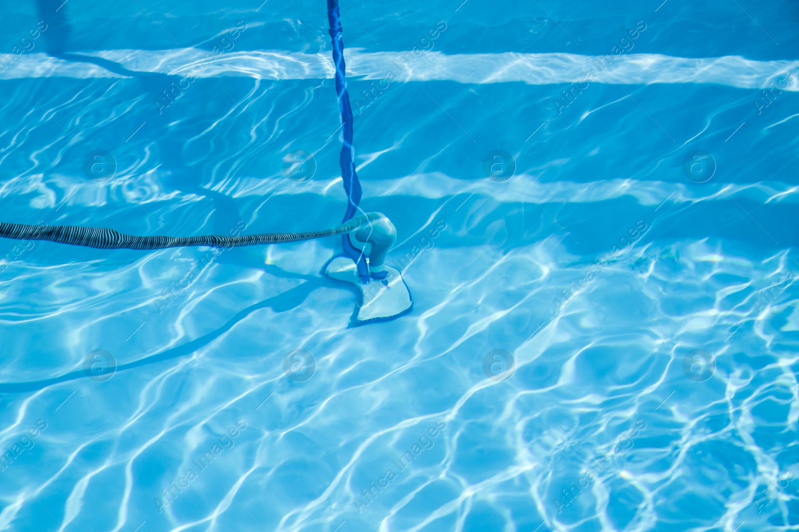 Photo of Cleaning outdoor swimming pool with underwater vacuum