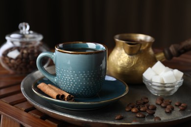 Photo of Turkish coffee. Freshly brewed beverage served on wooden table, closeup