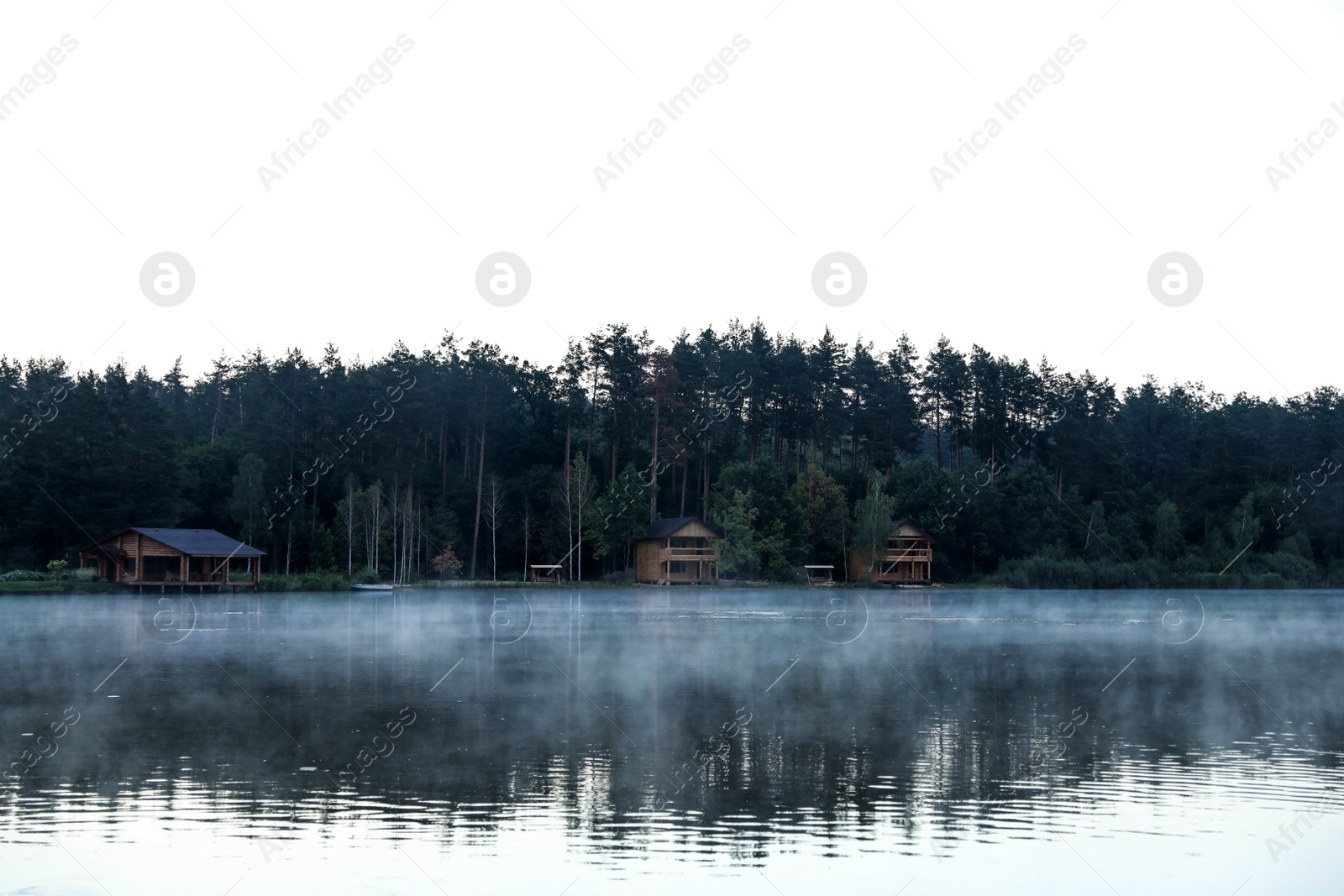 Photo of Beautiful landscape with forest and houses near lake. Camping season