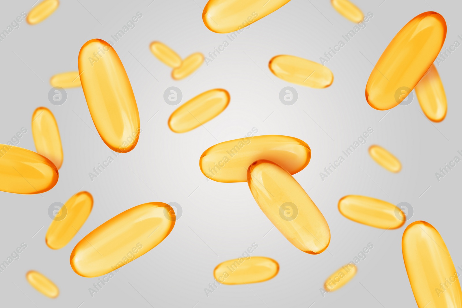 Image of Vitamin. Softgel capsules falling on light grey background