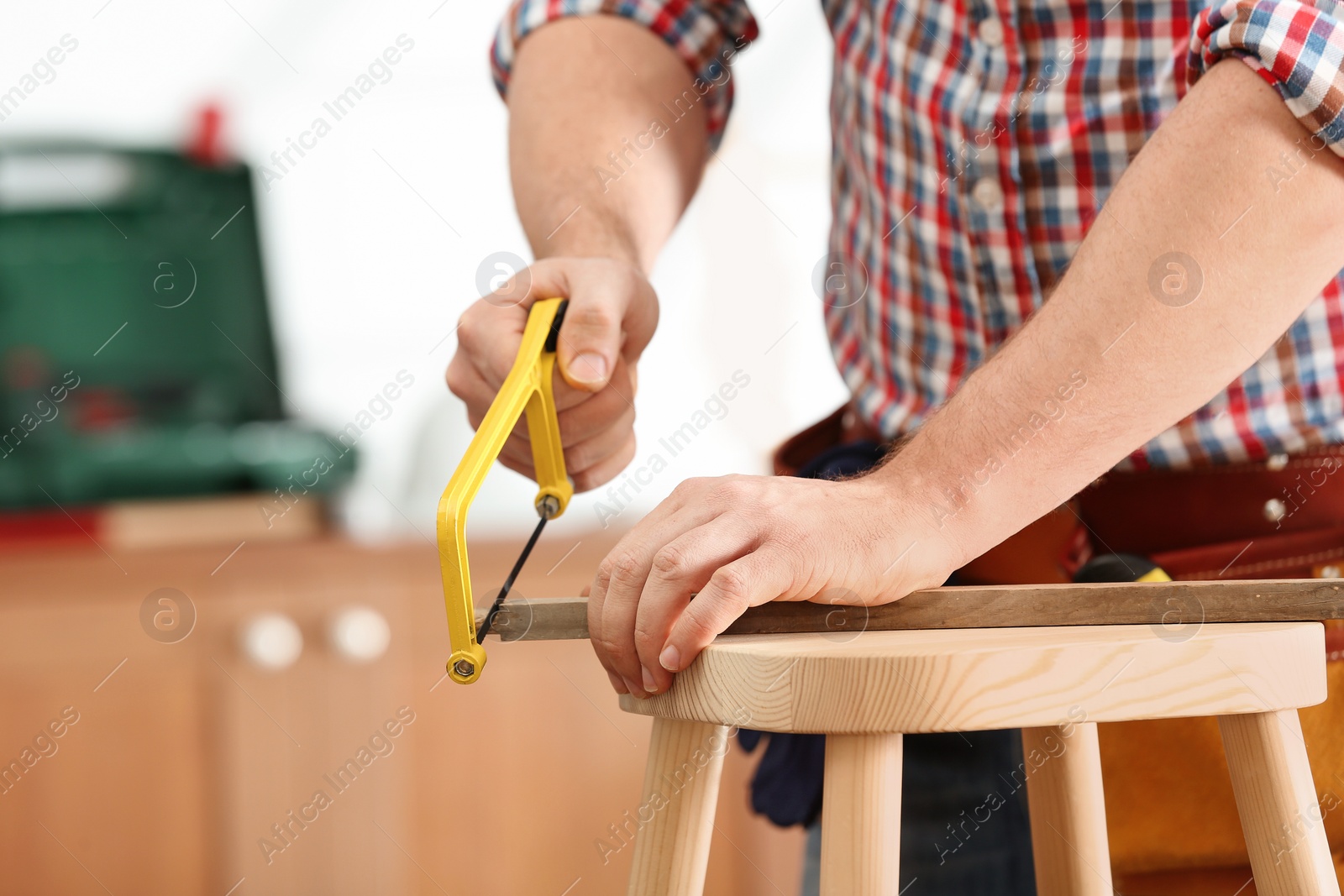 Photo of Man working with hand saw indoors, closeup. Home repair