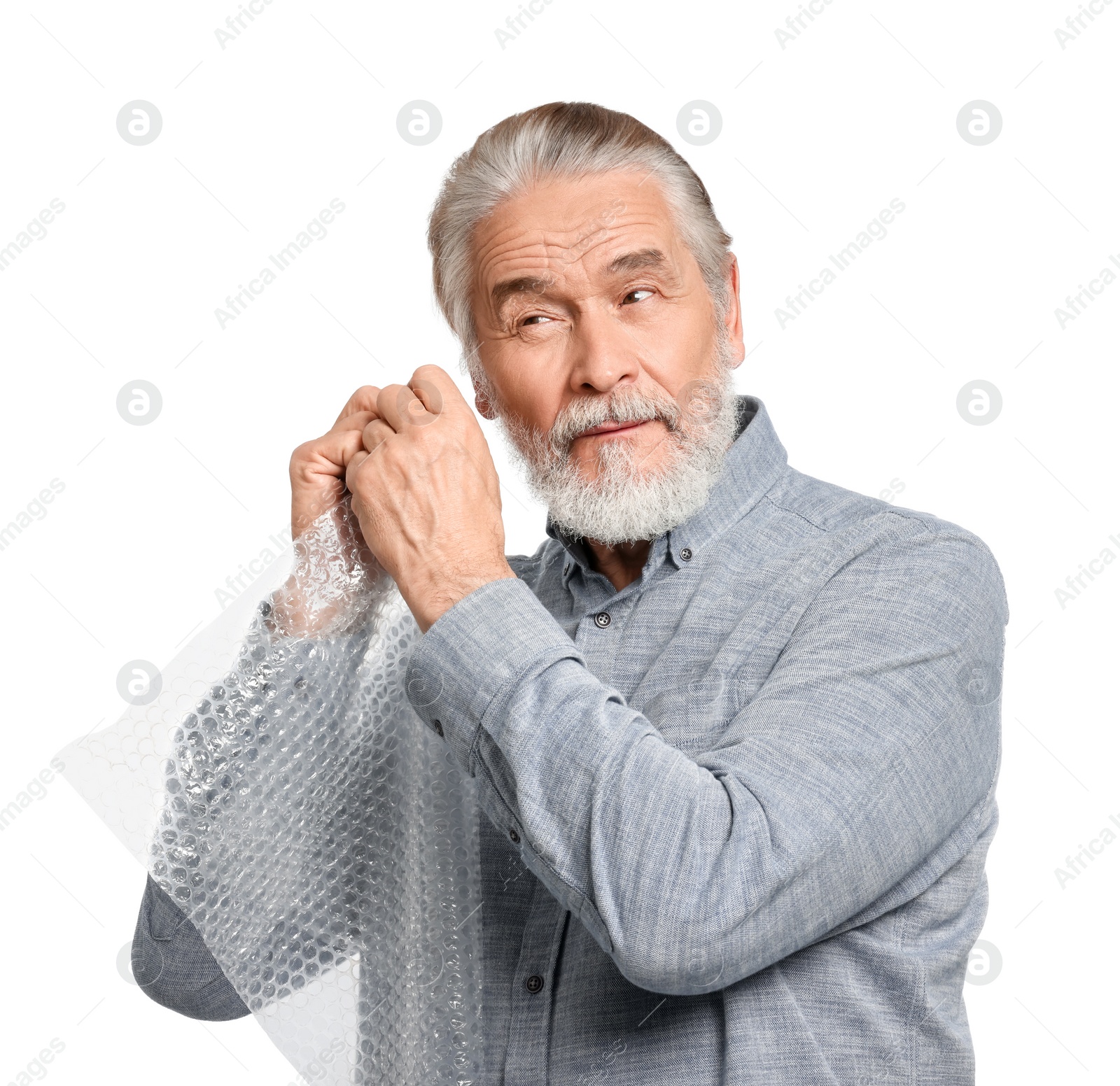 Photo of Senior man popping bubble wrap on white background. Stress relief