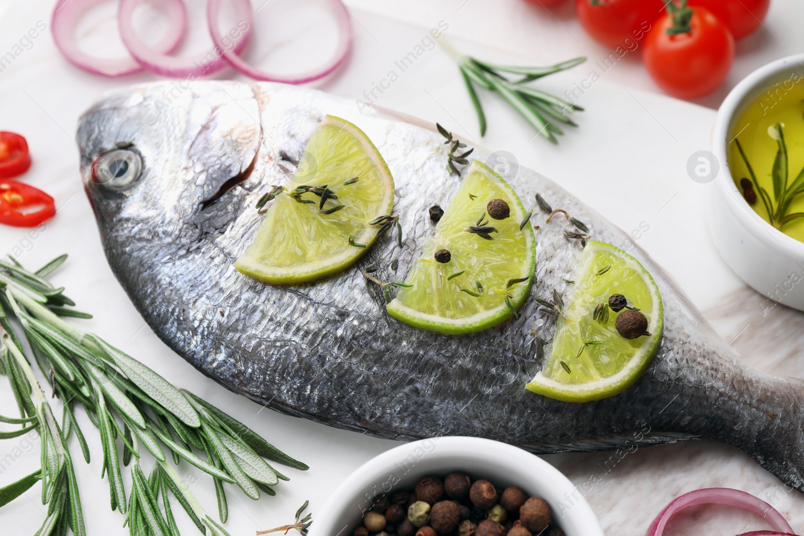 Photo of Fresh dorado fish and ingredients on white table, closeup