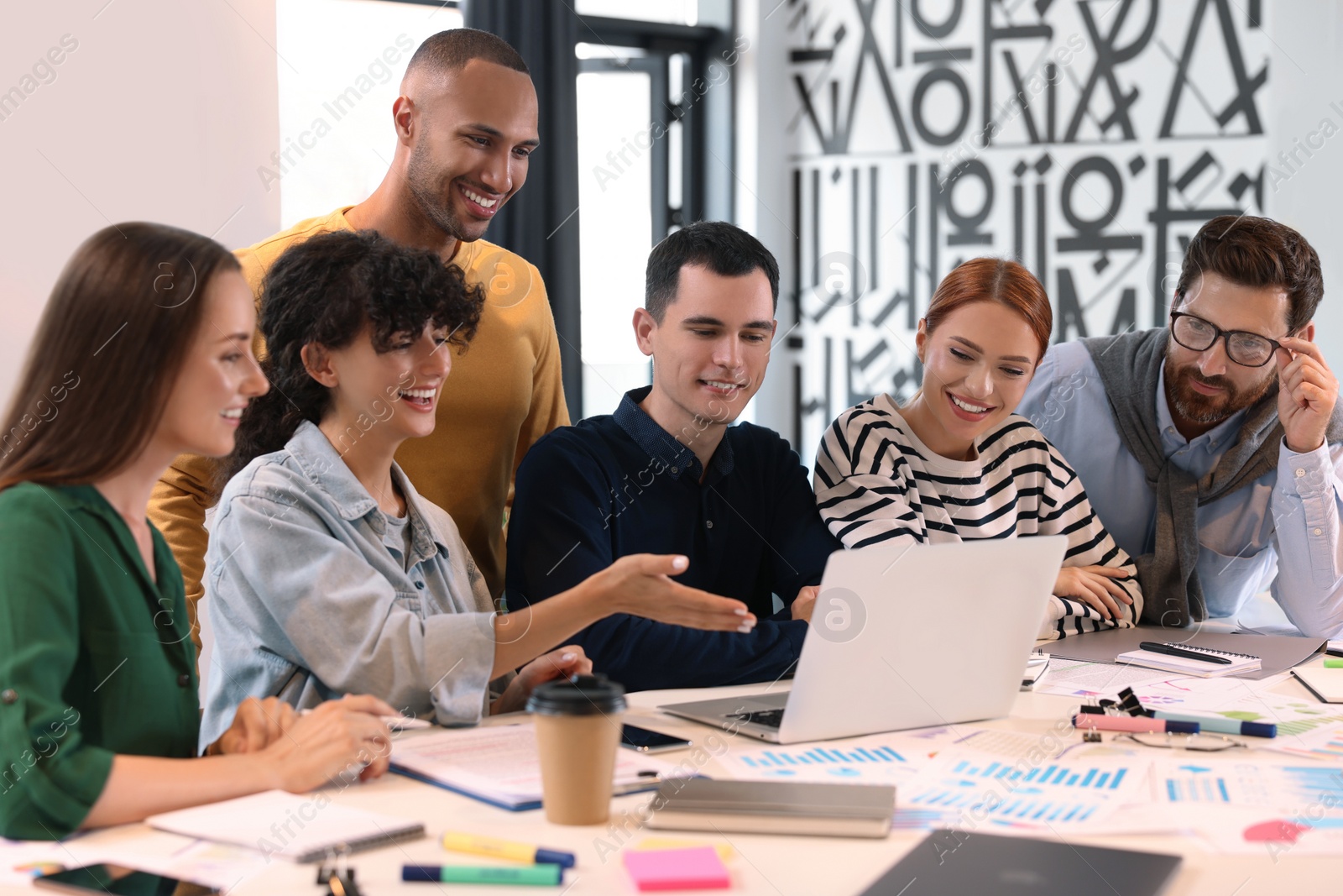 Photo of Team of employees working together at table in office. Startup project