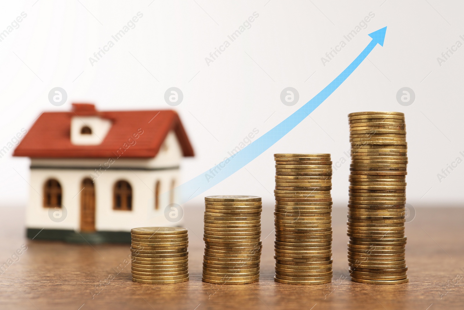 Image of Mortgage rate. Stacked coins, arrow and model of house