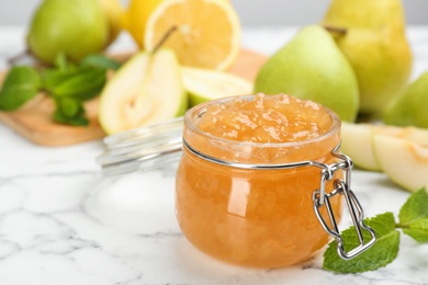 Delicious pear jam and fresh fruits on white marble table. Space for text