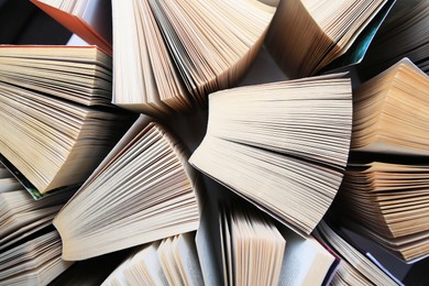 Collection of different books on white shelf, above view