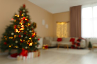 Photo of Blurred view of beautiful Christmas tree decorated with festive lights in stylish room. Interior design