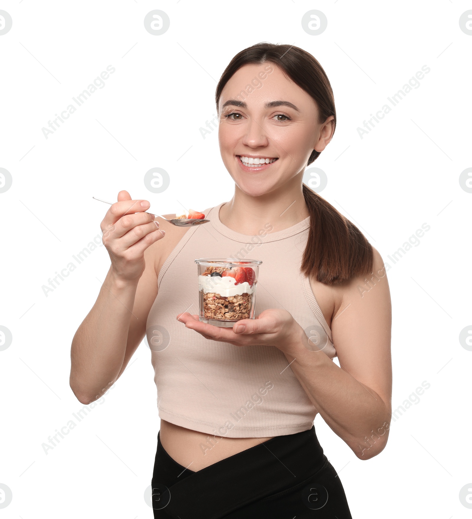 Photo of Happy woman eating tasty granola with fresh berries and yogurt on white background