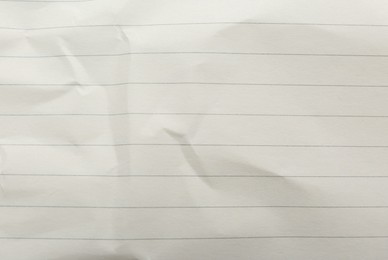 Photo of Crumpled lined notebook sheet as background, top view