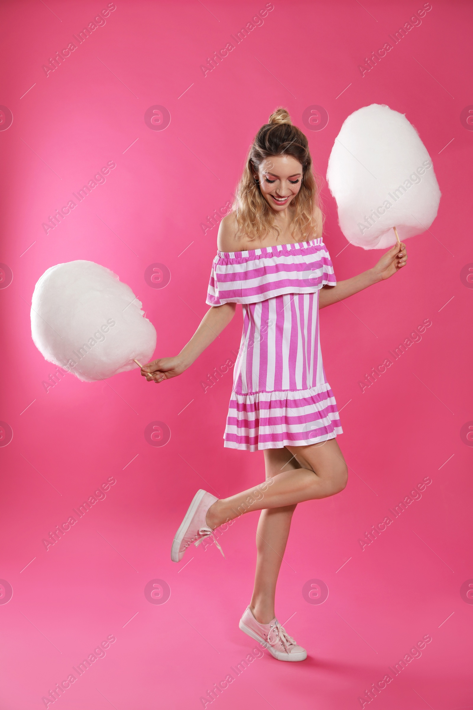 Photo of Full length portrait of pretty young woman with cotton candy on pink background