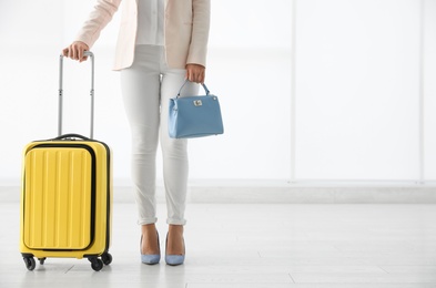 Photo of Businesswoman with yellow travel suitcase in airport. Space for text