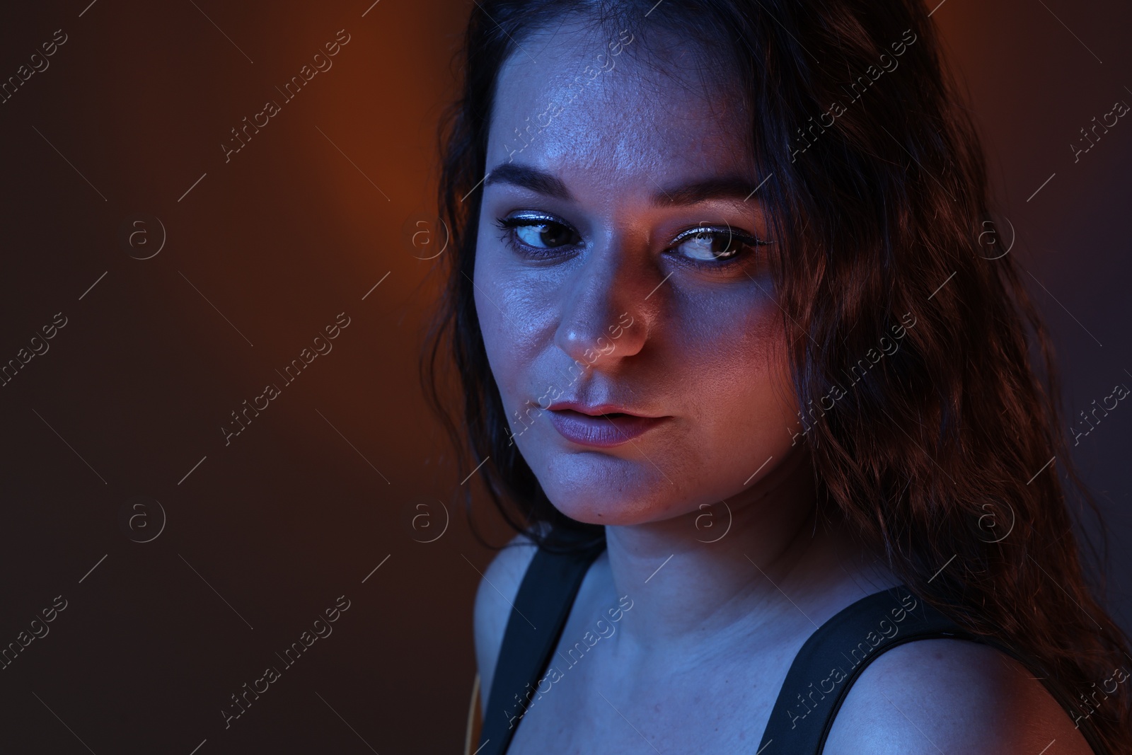 Photo of Portrait of beautiful young woman on color background with neon lights