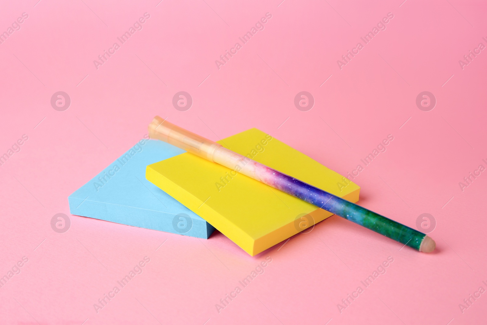 Photo of Colorful paper notes with erasable pen on pink background, closeup