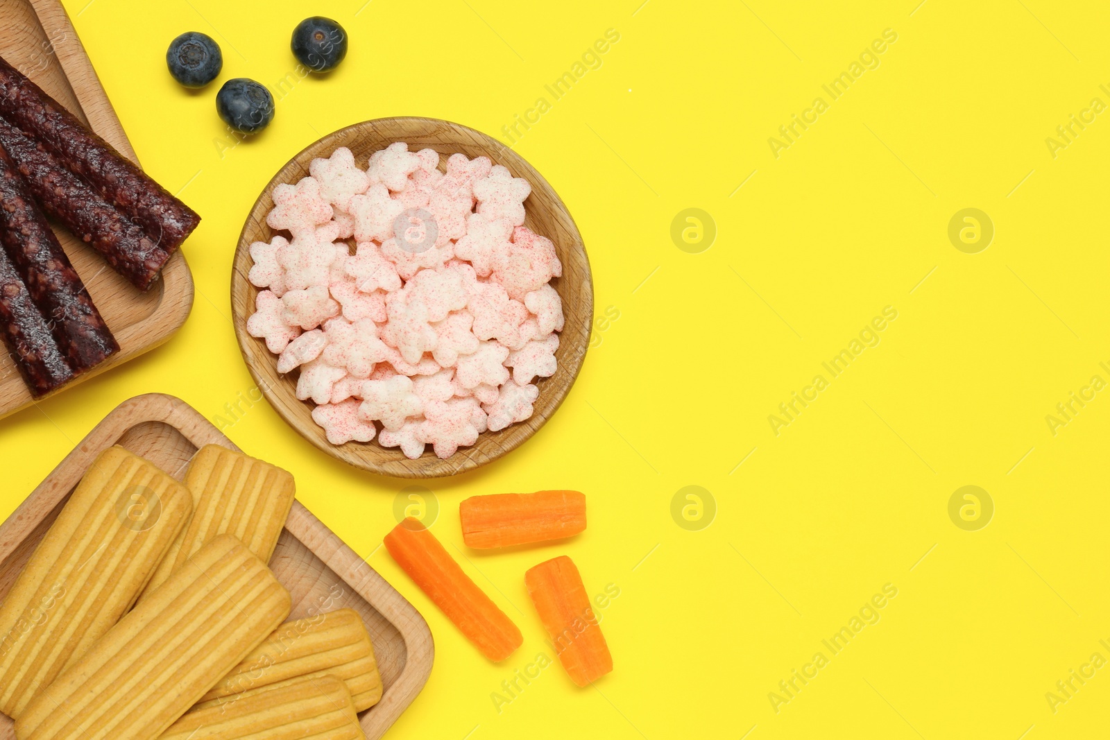 Photo of Different baby finger foods on yellow background, flat lay. Space for text