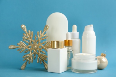 Beautiful composition with cosmetic products on light blue background. Winter care