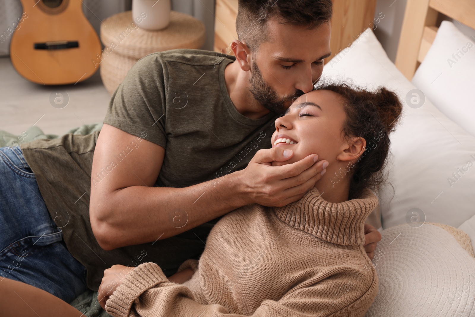 Photo of Lovely couple enjoying each other on bed at home