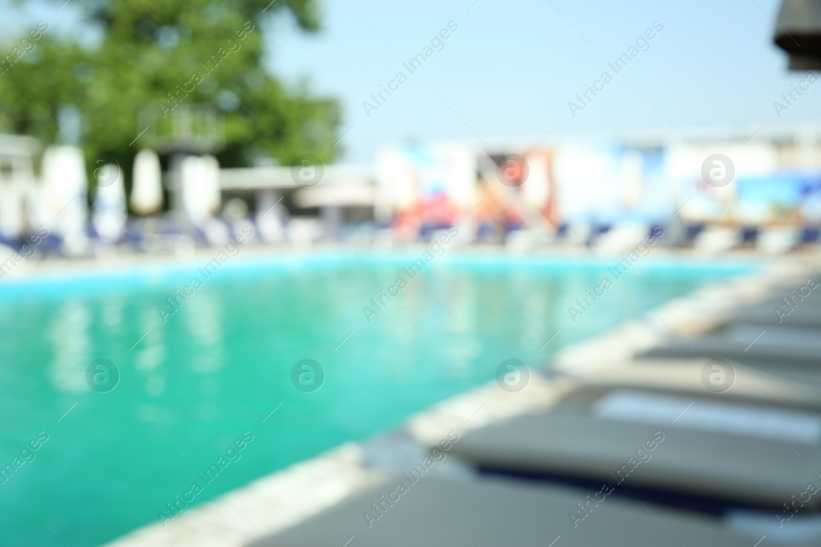 Photo of Blurred view of modern outdoor swimming pool on sunny day