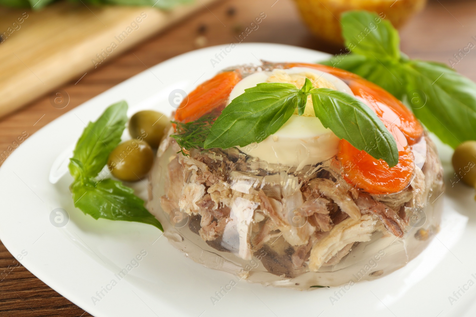 Photo of Delicious aspic with meat on wooden table, closeup