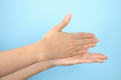 Photo of Woman showing word stop on color background, closeup. Sign language